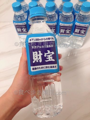 ミネラルウォーター財宝のペットボトルを手に持っている