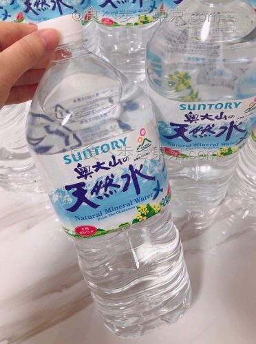 奥大山の天然水を手に持っているところ